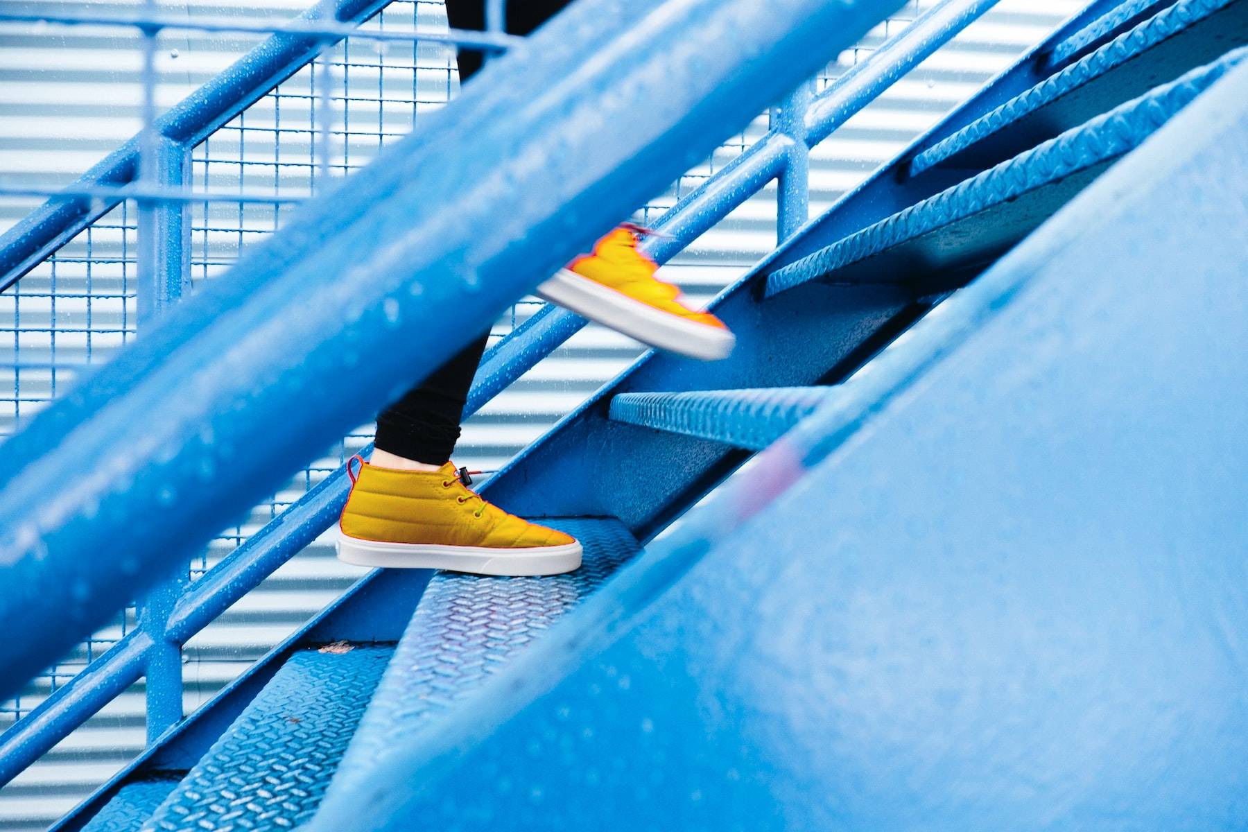 Person going up stairs blue