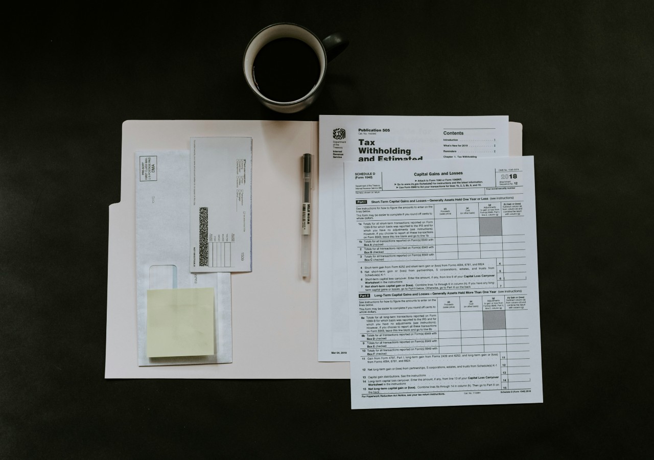 Paperwork in a folder with coffee on the desk